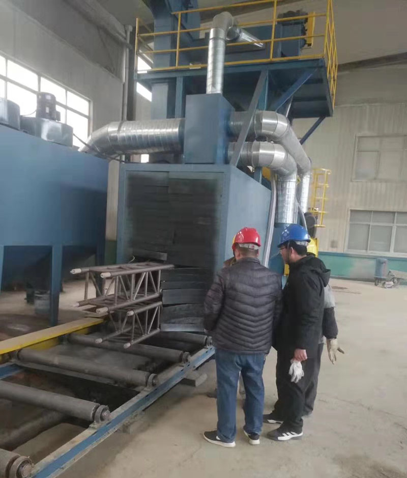 公司正在驗(yàn)收通過式拋丸機(jī)清理效果